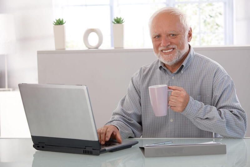 popular meme of old man smiling using computer